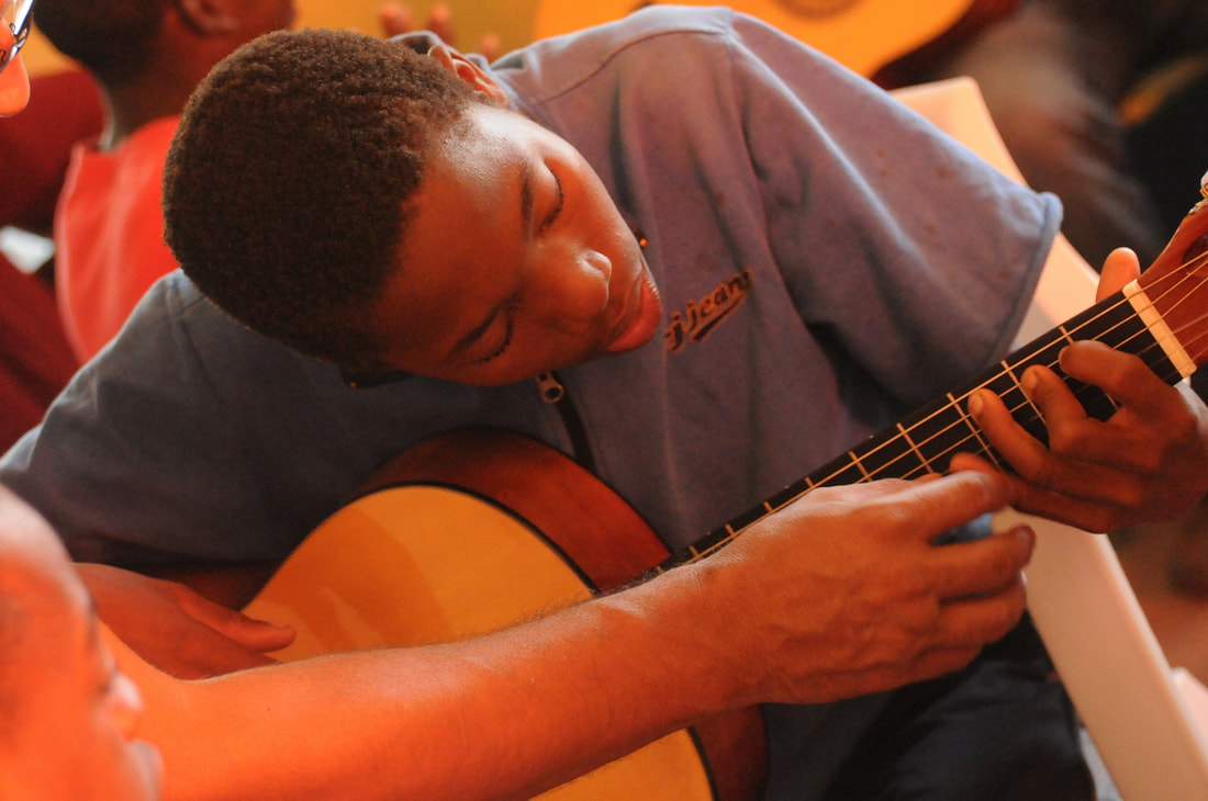 Adolescent qui prend un cours de guitare débutant avec son professeur