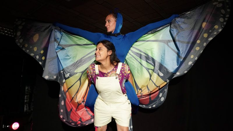 Cécile Doan interprétant un rôle dans le spectacle pour tout public l'éphémère de la compagnie le temps d'un conte et portant une danseuse déguisée en papillon
